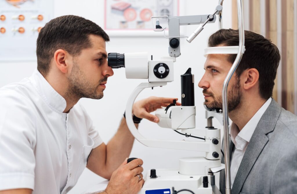 Optometrist performing an eye exam with specialized equipment.